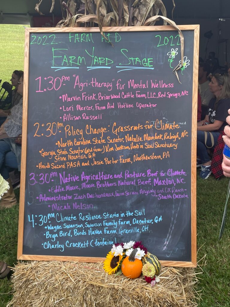 A chalk board displaying a list of activities taking place at a "farm yard stage"